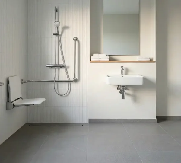 Salle de bain moderne avec douche PMR accessible, barres d'appui et siège intégré