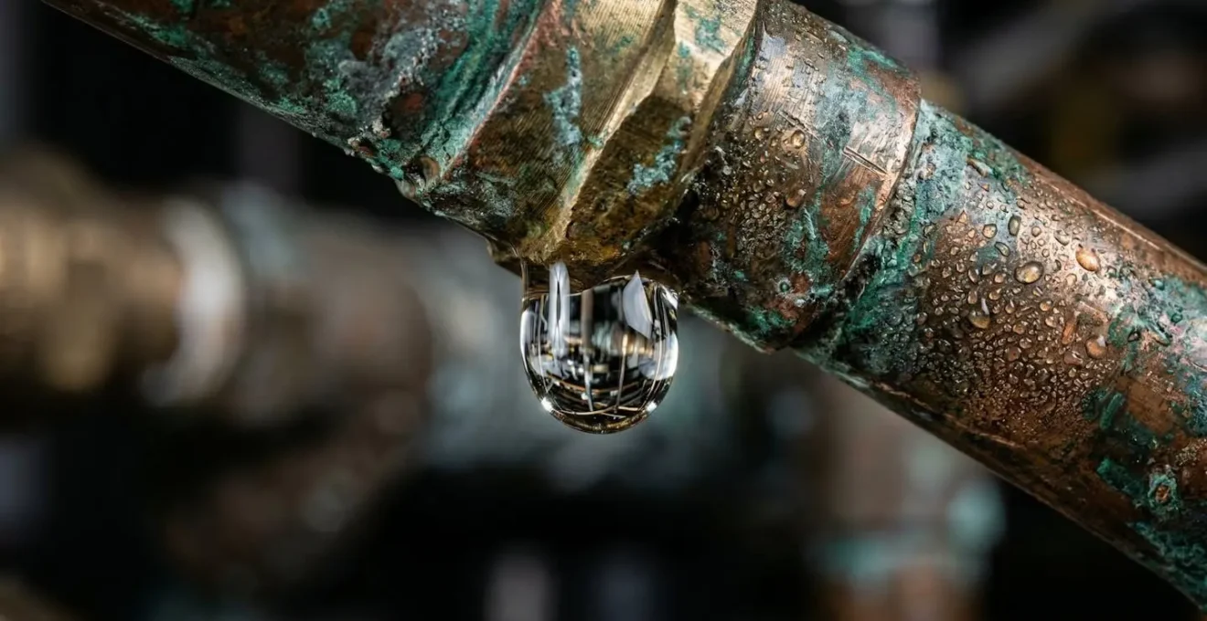 Macro d'une goutte d'eau se formant sur un joint de tuyauterie