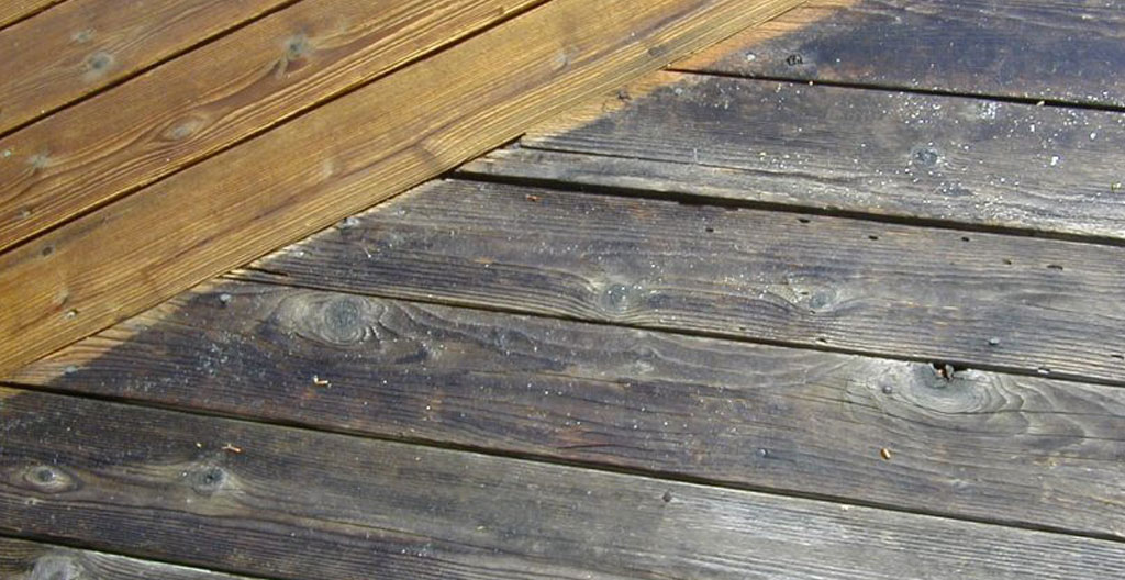 Zone humide visible sur terrasse en bois près d'une piscine indiquant une fuite souterraine